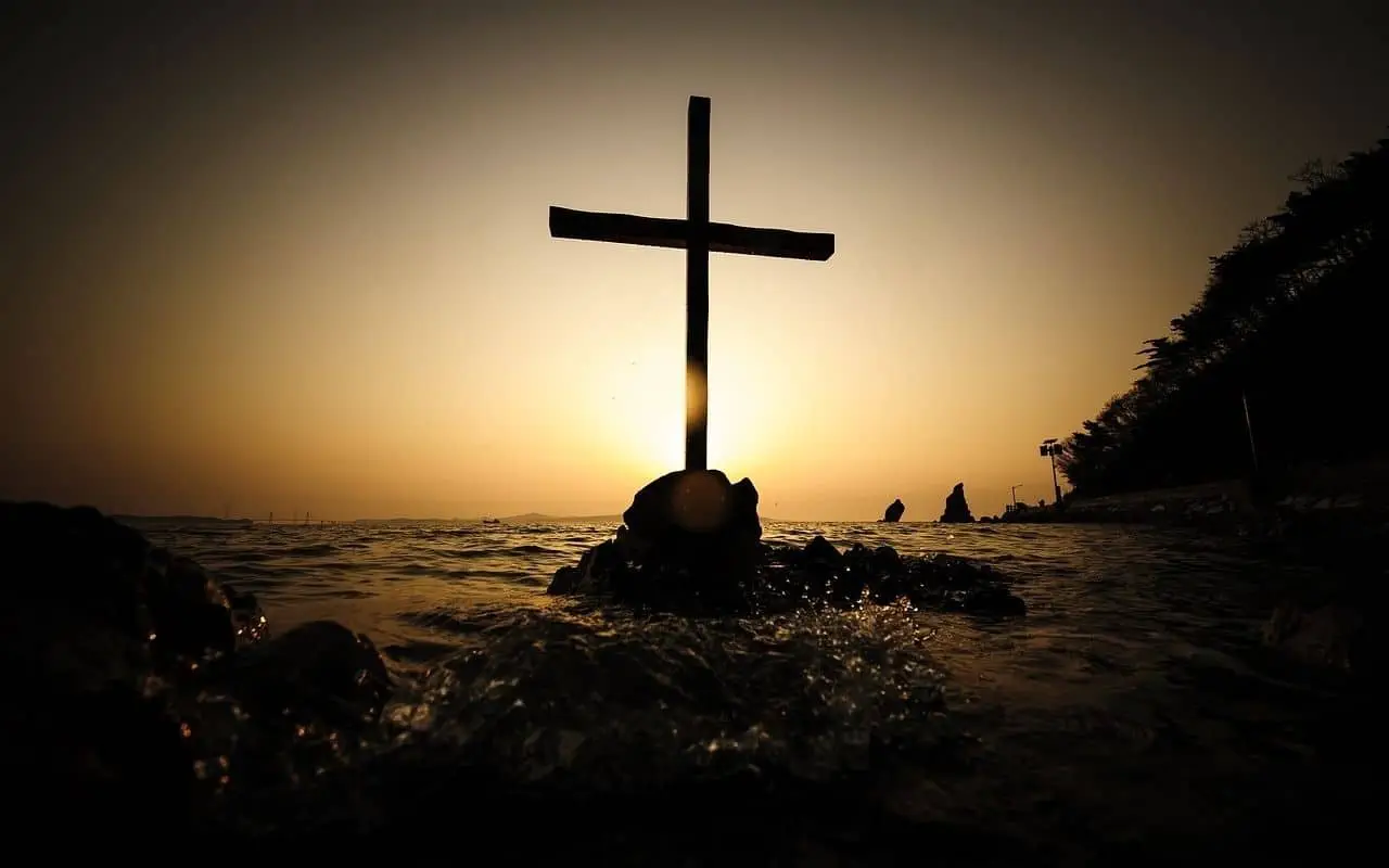 Kreuz in der Abendsonne am Wasser