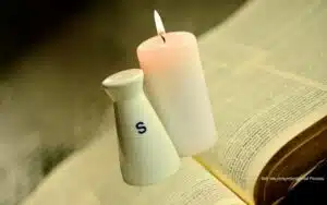 Kerze und Salz stehen auf der aufgeschlagenen Bibel